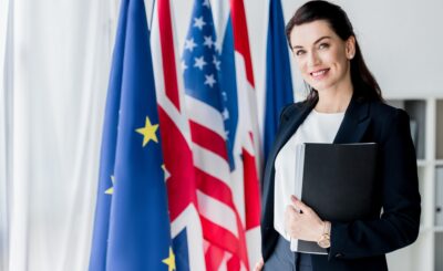 smiling ambassador looking at camera near flags