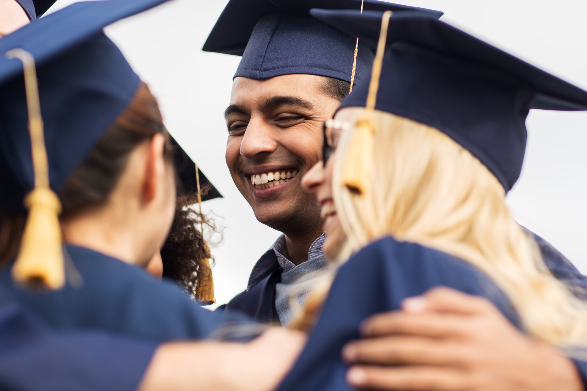 happy students or bachelors in mortar boards